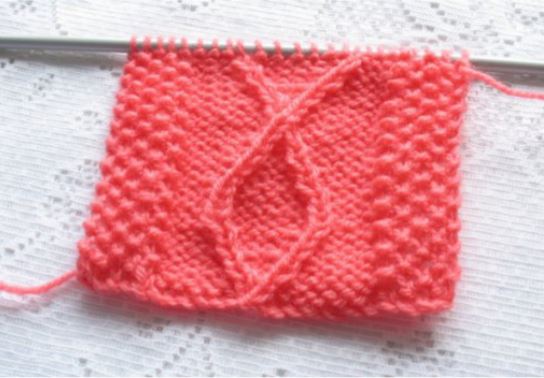 This knitting sample shows the diamond pattern flanked by moss stitch borders